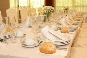 una larga mesa blanca con platos, vasos y comida en Hotel Barreiro, en Leira