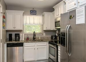 a kitchen with white cabinets and a stainless steel refrigerator at House# 60 Point of View (pet friendly) in Centre