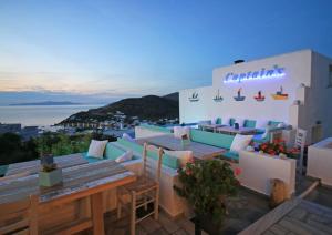 a restaurant with tables and chairs on a roof at Captain's in Kini