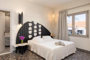um quarto com uma cama grande e uma janela em Eftopia Beachfront 3-bedrooms apartment em Kokkari