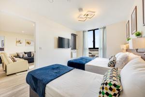 a bedroom with two beds and a living room at The Burke Suite - 3 Westminster Park in Liverpool