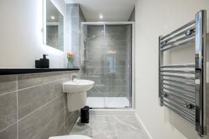 a bathroom with a shower and a toilet and a sink at The Burke Suite - 3 Westminster Park in Liverpool