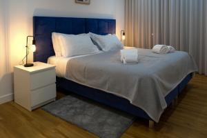 a bedroom with a large bed with two towels on it at Blue Dreams in Queluz