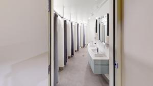 uma casa de banho com uma fila de lavatórios e espelhos em Auberge Jeunesse QBEDS Hostel em Quebeque
