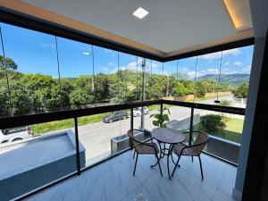 a balcony with a table and chairs and a tub at Lindo apartamento a 400 metros da praia com selo azul de qualidade in Governador Celso Ramos