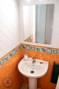 a bathroom with a white sink and a mirror at Casita Molino de Erillas in Alora