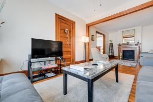 a living room with a tv and a table at Buffalo Apt with Balcony about 3 Mi to Downtown! in Buffalo