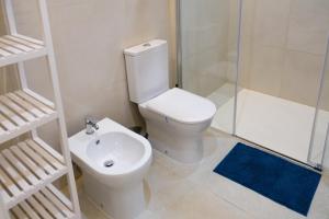 uma casa de banho com um WC, um chuveiro e um lavatório. em Blue Dreams em Queluz