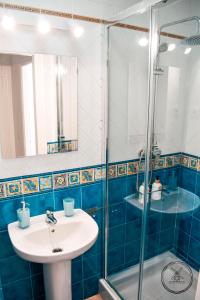 een badkamer met een wastafel en een glazen douche bij Casita Molino de Erillas in Alora