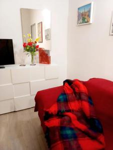una sala de estar con un sofá rojo y un jarrón de flores en L'approdo, en Venecia
