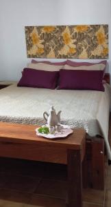 a bed with a tea set on a wooden table at Sua casa na Serra da Mantiqueira. 1h de SP in Extrema