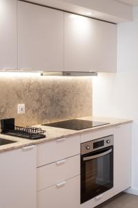 uma cozinha com armários brancos e um forno com placa de fogão em The Haus - Alegria em Lisboa