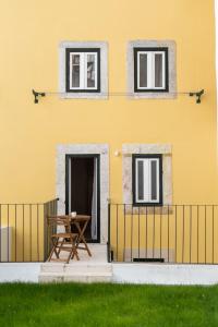 uma casa amarela com uma mesa de piquenique em frente em The Haus - Alegria em Lisboa