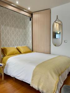1 dormitorio con 1 cama blanca grande con almohadas amarillas en Estudio Platería Centro Histórico en Murcia
