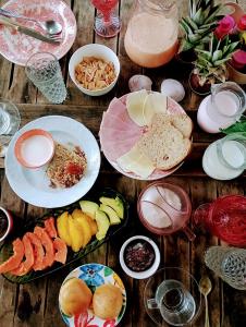 a wooden table topped with plates of food and drinks at CASA JANE in Imbituba
