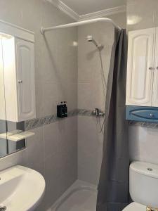 ein Bad mit einer Dusche, einem WC und einem Waschbecken in der Unterkunft Apartamento Boiro centro in Boiro