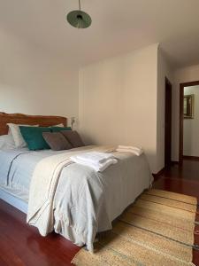 a bedroom with a large bed with blue pillows at Apartamento Boiro centro in Boiro