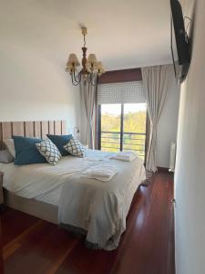 ein Schlafzimmer mit einem großen Bett und einem Fenster in der Unterkunft Apartamento Boiro centro in Boiro