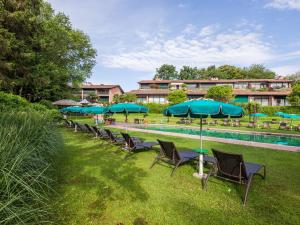 una fila de sillas con sombrillas junto a una piscina en Park Hotel Principe - Ticino Hotels Group, en Lugano