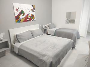 - une chambre avec 2 lits et un tableau mural dans l'établissement B&B La Finestra sul Mare, à Milazzo