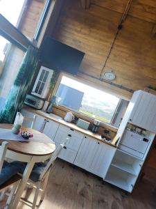 a kitchen with white cabinets and a table and a window at Dream Catcher House 