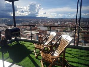 two chairs on a balcony with a view of a city at penthouse panorámico in Sucre