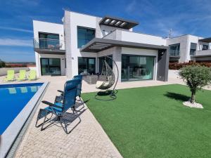 a house with a yard with two chairs and a swimming pool at Villa Joia in Bombarral