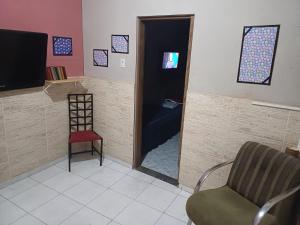 a room with a door into a bedroom with a chair at Pousada Mara Mar Niterói in Niterói
