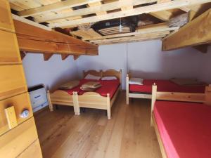 Habitación pequeña con 2 camas y suelo de madera. en Rifugio Alpe Bonze, en Donnaz