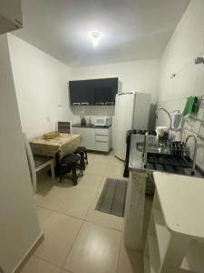 eine Küche mit einem Tisch und eine Küche mit einem Kühlschrank in der Unterkunft Samambaia QI 616 in Brasilia