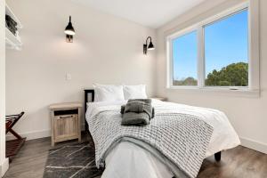 a white bedroom with a bed and a window at Play Thru-MTB Oasis in Bella Vista