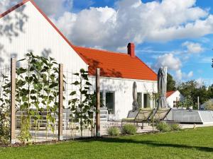 a white house with an orange roof and chairs at Holiday home Gotlands Tofta VII in Tofta