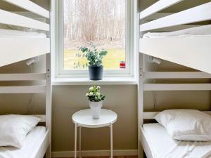 a room with bunk beds with a window and a table with flowers at Holiday home Gotlands Tofta VII in Tofta