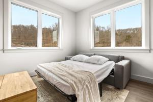 a bedroom with a bed and two windows at Sugar Bridge-MTB Oasis in Bella Vista