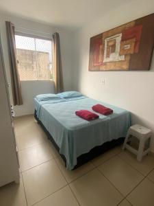 a bedroom with a bed with two red pillows on it at Samambaia QI 616 in Brasilia