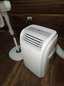 a white air conditioner sitting on the floor next to a fan at Hotel Calamari Baru in Playa Blanca