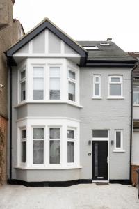 ein weißes Haus mit vielen Fenstern in der Unterkunft Luxurious London Studios in Harrow