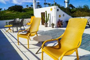 a group of yellow chairs and a table on a patio at Villa Marrachinho in Albufeira