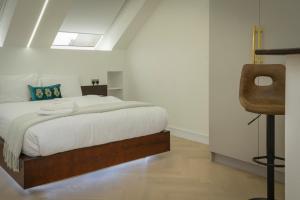 a bedroom with a bed and a chair in it at Luxurious London Studios in Harrow