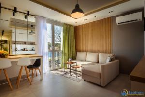 a living room with a couch and a table at Seafront Residence Makarska in Makarska