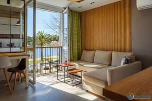 a living room with a couch and a balcony at Seafront Residence Makarska in Makarska