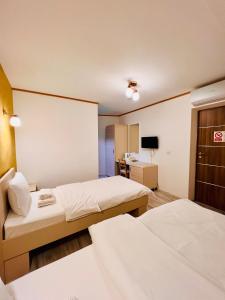 a hotel room with two beds and a television at Hotel Marina srl in Bucharest +25 photos