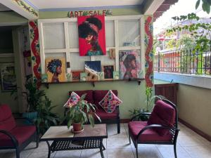 a waiting room with red chairs and a table at Hotel El Delfin in Lívingston