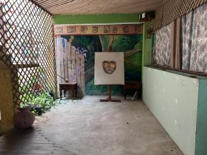 a painting on a stand in a room with a mural at Hotel El Delfin in Lívingston