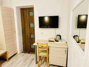 a room with a desk with a chair and a television at Hotel Marina srl in Bucharest