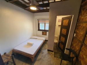 a small room with a bed and a chair at Coleto Siargao in San Isidro