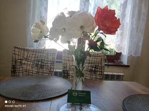 un jarrón de flores sentado sobre una mesa en Domowe Zacisze w Nickulinie en Rajcza