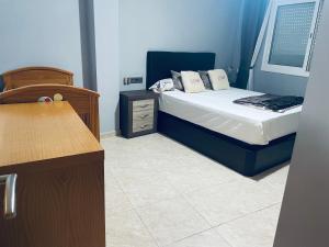 ein kleines Schlafzimmer mit einem Bett und einem Nachttisch in der Unterkunft Canar in Alcanar