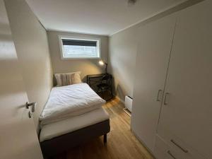 Habitación pequeña con cama y ventana en Apartment close to Aalesund center, en Ålesund