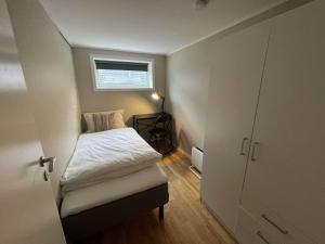 a small bedroom with a bed and a window at Apartment close to Aalesund center in Ålesund